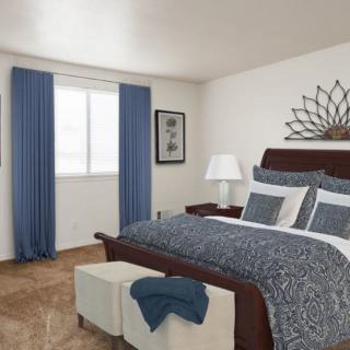 A cozy bedroom with blue accents and tasteful decor.