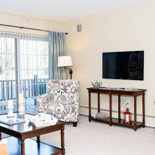 A cozy living room featuring a modern design, complete with a television, comfortable seating, and ample natural light.