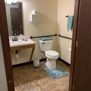 Bathroom with a sink, toilet, and aqua-colored accessories.