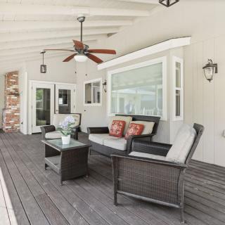 A cozy and inviting patio with wicker furniture and a ceiling fan, perfect for outdoor relaxation.