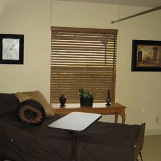 A cozy living room featuring a sofa, window with blinds, and wall art.