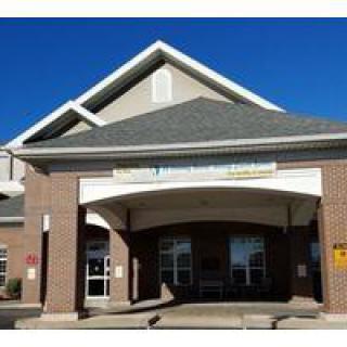 A commercial building with a brick exterior and pointed roof, displaying an entrance area.