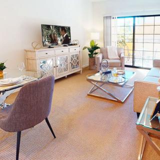 A modern and bright living room with a sofa, coffee table, television, and elegant decor.