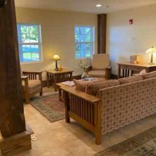 A cozy living room with wooden furniture and warm lighting.