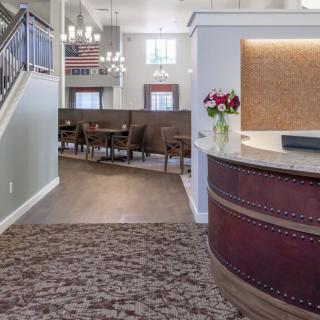 A modern reception area featuring a curved desk, elegant lighting, and comfortable seating.