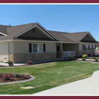 A single-story suburban house with a well-maintained lawn and driveway.