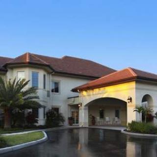 A large residential building with a red-tiled roof and landscaped surroundings.