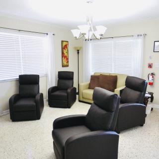 A cozy living room with black recliners and a beige sofa.