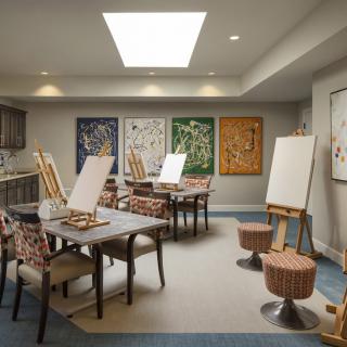 A well-lit art studio with easels and paintings displayed on the walls.