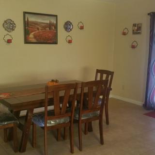 A dining room with a wooden table and chairs, adorned with wall art and decorations.