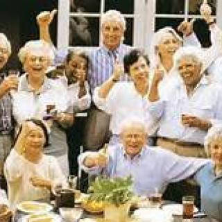 A joyful group of elderly people celebrating together indoors.