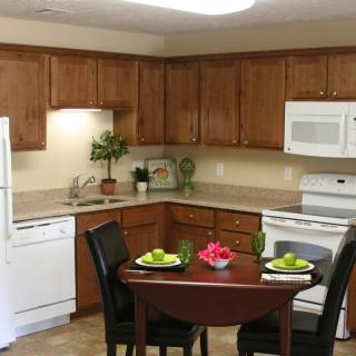 A cozy kitchen and dining area featuring wooden cabinets and modern appliances.