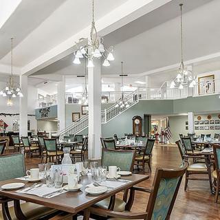 A spacious and elegantly decorated restaurant interior with neatly arranged tables and chairs.