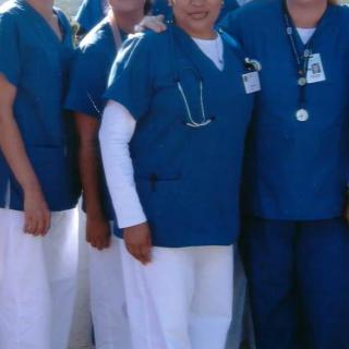 A group of medical staff in blue uniforms posing for a photo.