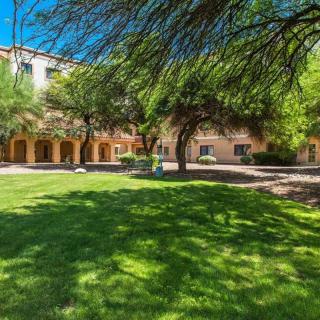 A sunny day on a peaceful campus with trees and well-maintained lawns.