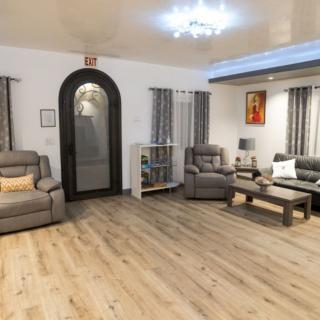 A cozy and well-decorated living room with sofas, a coffee table, and elegant wooden flooring.