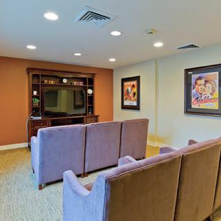 Cozy home theater room with comfortable seating and wall-mounted artwork.
