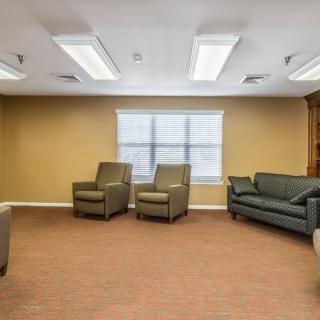 A calm and comfortable waiting room with chairs, a sofa, and a window.