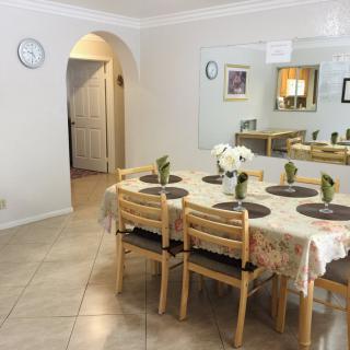 A tidy dining area with a table set for six, featuring wooden chairs and decorative elements.