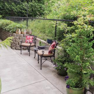 A serene patio setting with chairs and lush greenery.