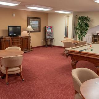 A cozy game room with a pool table, seating area, and a television.