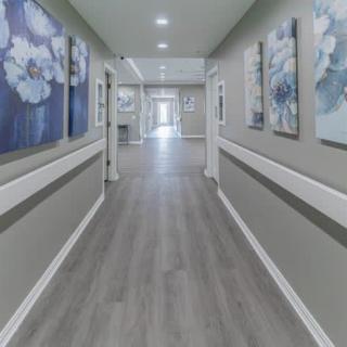 A modern hallway featuring artwork on the walls and sleek flooring.