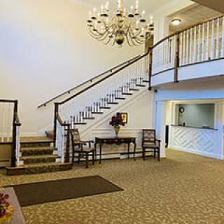 A spacious lobby with a grand staircase and chandelier.