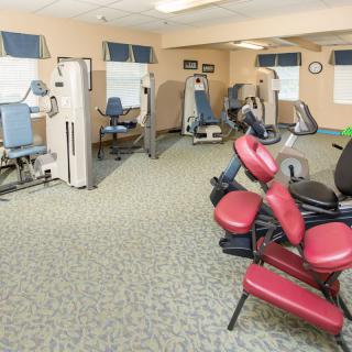 A gym featuring various exercise machines in a spacious indoor setting.