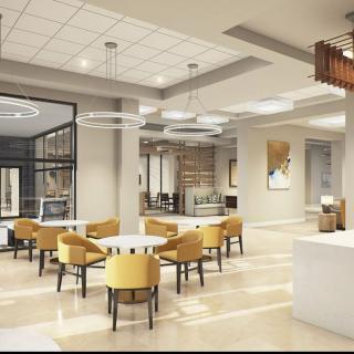A modern office lobby with yellow chairs and contemporary lighting.