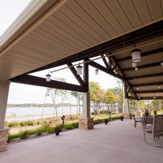 A spacious patio with outdoor seating overlooking a serene lake.