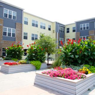 A beautiful apartment complex featuring vibrant gardens and modern architecture.