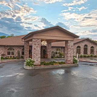 A welcoming entrance to a beautifully designed residential building under a dramatic sky.