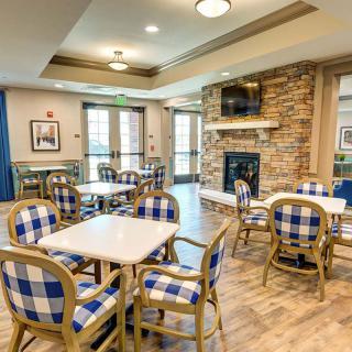 A cozy dining area with checkered chairs and a brick fireplace.