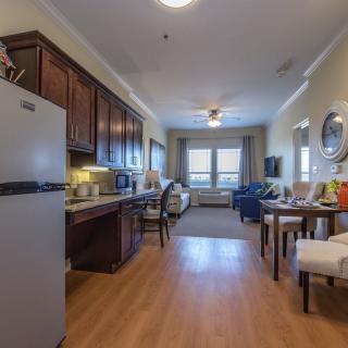 A cozy apartment interior with a kitchen and living area, featuring wooden floors and contemporary furniture.
