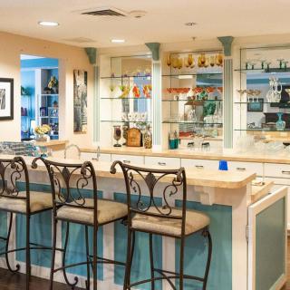 A stylish home bar with elegant bar stools and glass shelving.