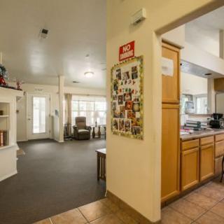 A cozy open-plan living area with a view of the kitchen and seating space.