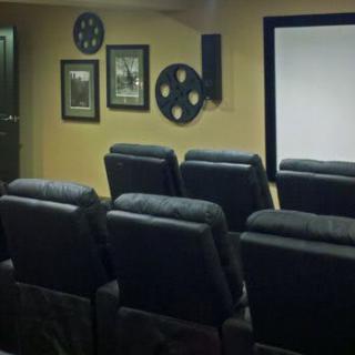 A cozy home theater setup with comfortable seating and a large projector screen.