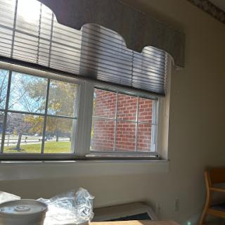 A view from an interior room showcasing a window with blinds, revealing an outdoor scene.