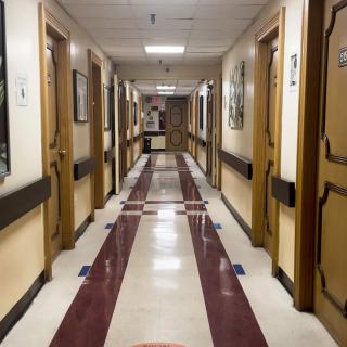 A well-lit corridor with multiple doors on either side.