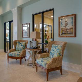 A cozy lobby area with patterned chairs, artwork on the walls, and soft lighting.