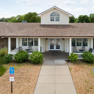 A suburban house with a front porch and landscaped garden.