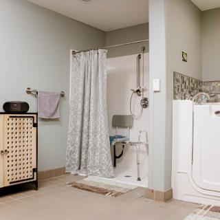 A modern bathroom featuring a shower with a curtain, a towel rack, and storage cabinets.