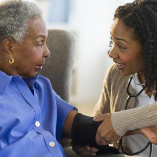 A healthcare professional measures a patient's blood pressure.