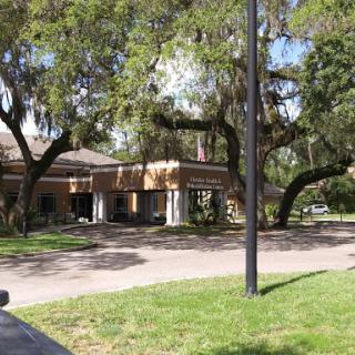 A view of a suburban building surrounded by lush greenery and trees.