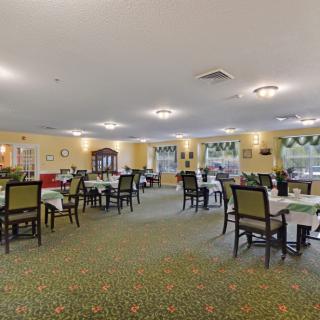 A spacious and well-lit dining room with neatly arranged tables and chairs.