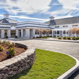 A well-designed building with a landscaped entrance and clear blue sky.
