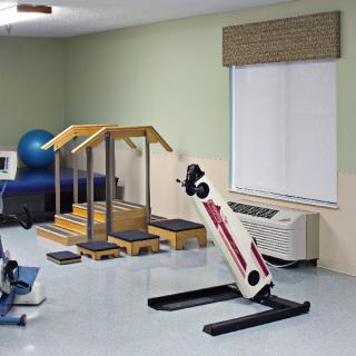 A physical therapy room equipped with various rehabilitation exercise machines.
