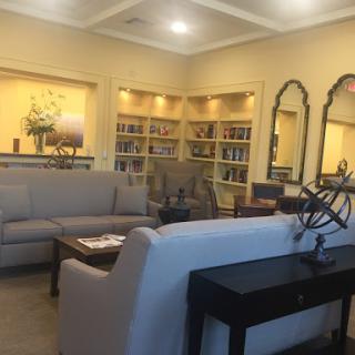 A cozy and inviting living room with modern furniture and well-organized shelves.