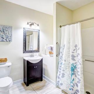 A modern bathroom with a stylish vanity, mirror, and floral shower curtain.
