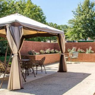 A cozy outdoor gazebo with patio furniture on a sunny day.